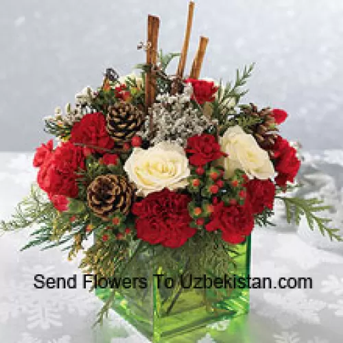 Send this bouquet of holiday colours - white roses, red carnations and Christmas greens - to express your happiest holiday wishes. Arranged in a glass cube with cinnamon sticks and pinecones, it's a wonderful gift for anyone on your list (Please Note That We Reserve The Right To Substitute Any Product With A Suitable Product Of Equal Value In Case Of Non-Availability Of A Certain Product)